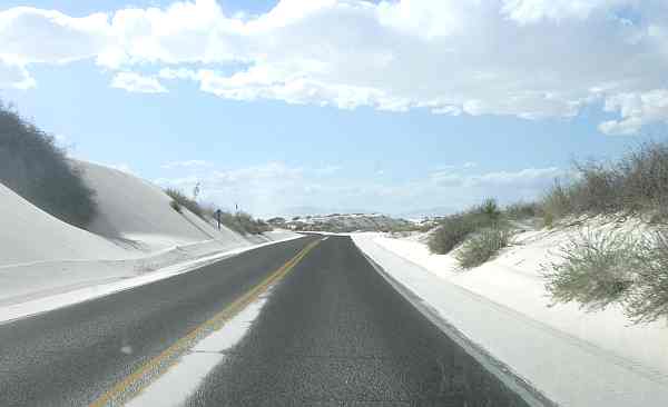 Sand covered road leading through White Sands National Monument.