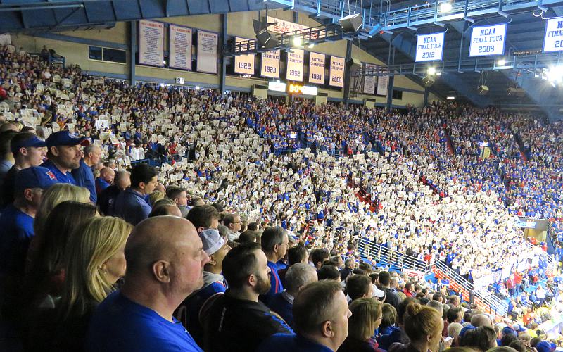 Students holding up the University Daily Kansan during player introductions