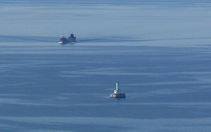 Freighter and lighthouse inthe Straits of Mackinac